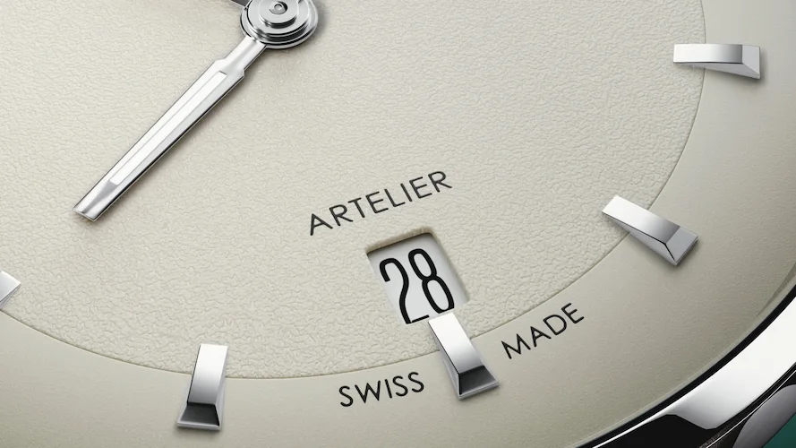 Detalle macro del sello Swiss Made y ventana de fecha a las 6 horas en la esfera del reloj Oris Artelier